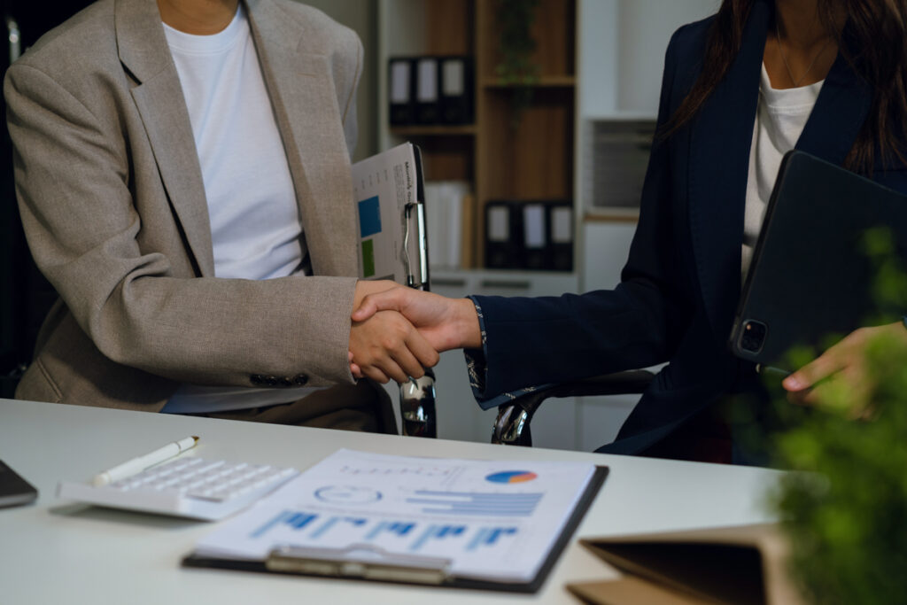 Consultant and their client shaking hands at a meeting