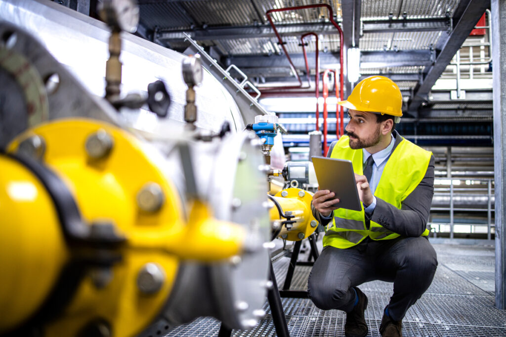 Industrial worker performing an inspection in an oil and gas production facility