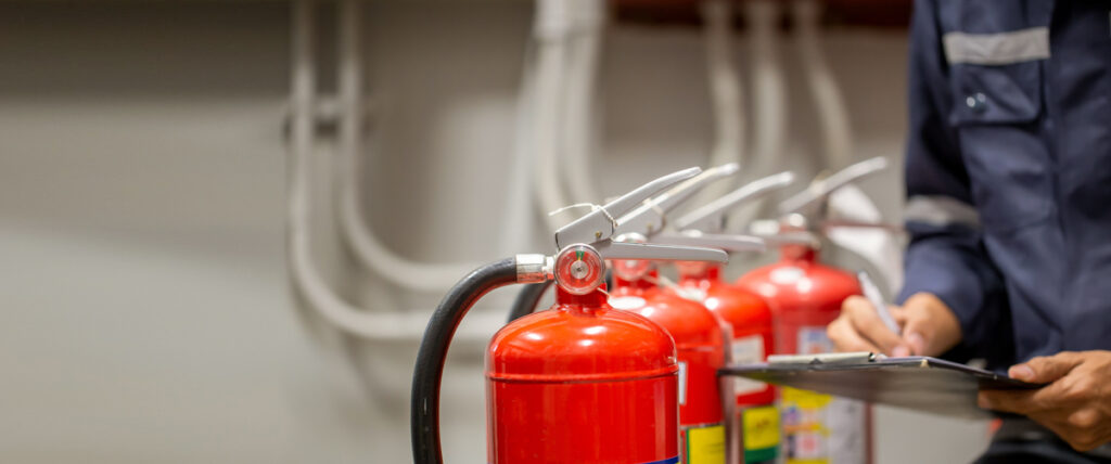 Inspector ensuring fire extinguishers are in compliance with regulations