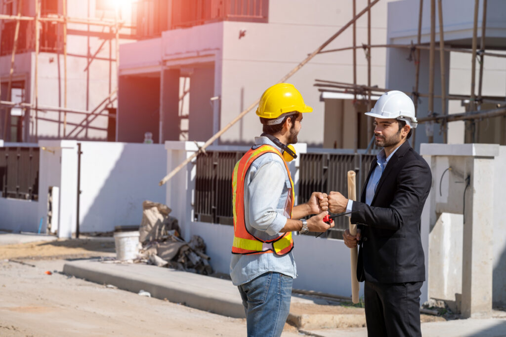 Businessman and architect shake hands at construction site