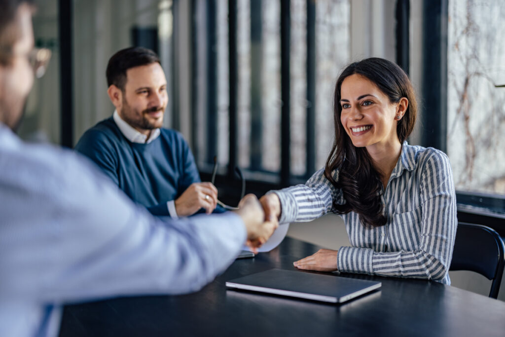 Consultant shaking hands with client at business meeting